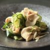 黒い器に盛りつけられた、豚しゃぶと香味野菜（ミョウガ・大葉・きゅうり）の和風サラダ。瑞々しい食感と彩りが際立つ夏の涼やかな一品。
