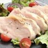 彩り野菜の上にしっとり焼かれた鶏むね肉のスライスが並ぶチキンサラダ。ミニトマトと赤玉ねぎも添えられ、やさしい塩と黒こしょうが香る一皿。