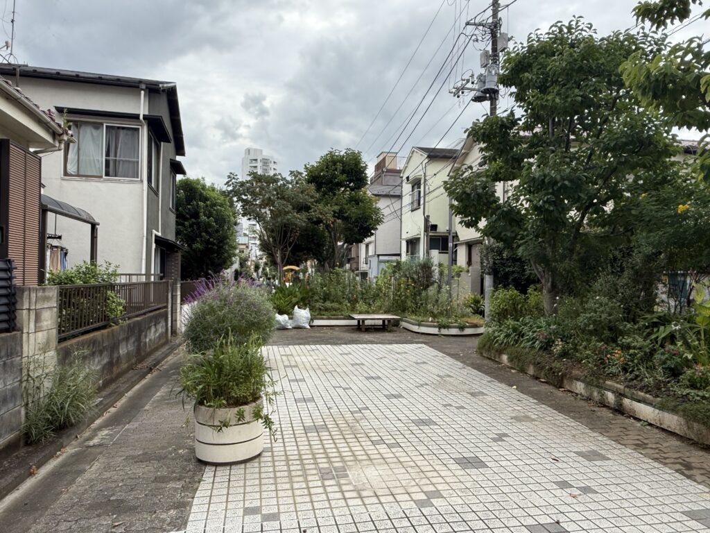 立会川の緑道の写真（タイル敷きの道と植え込み）