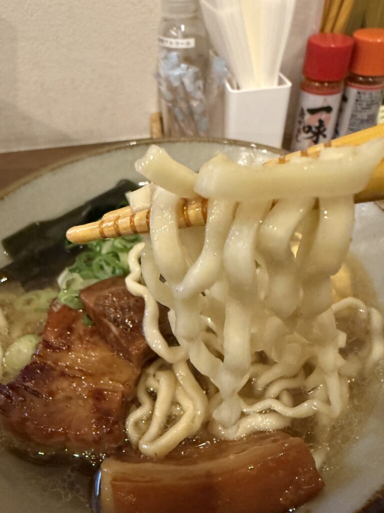 箸で持ち上げた中太ちぢれ麺