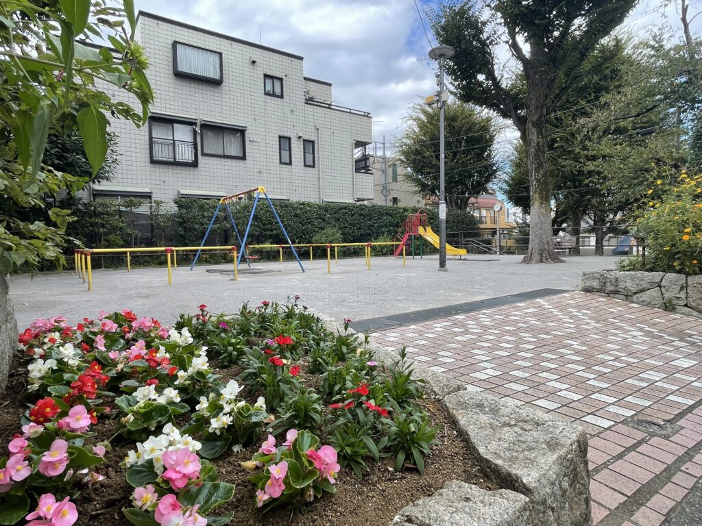 花壇の奥にブランコと滑り台