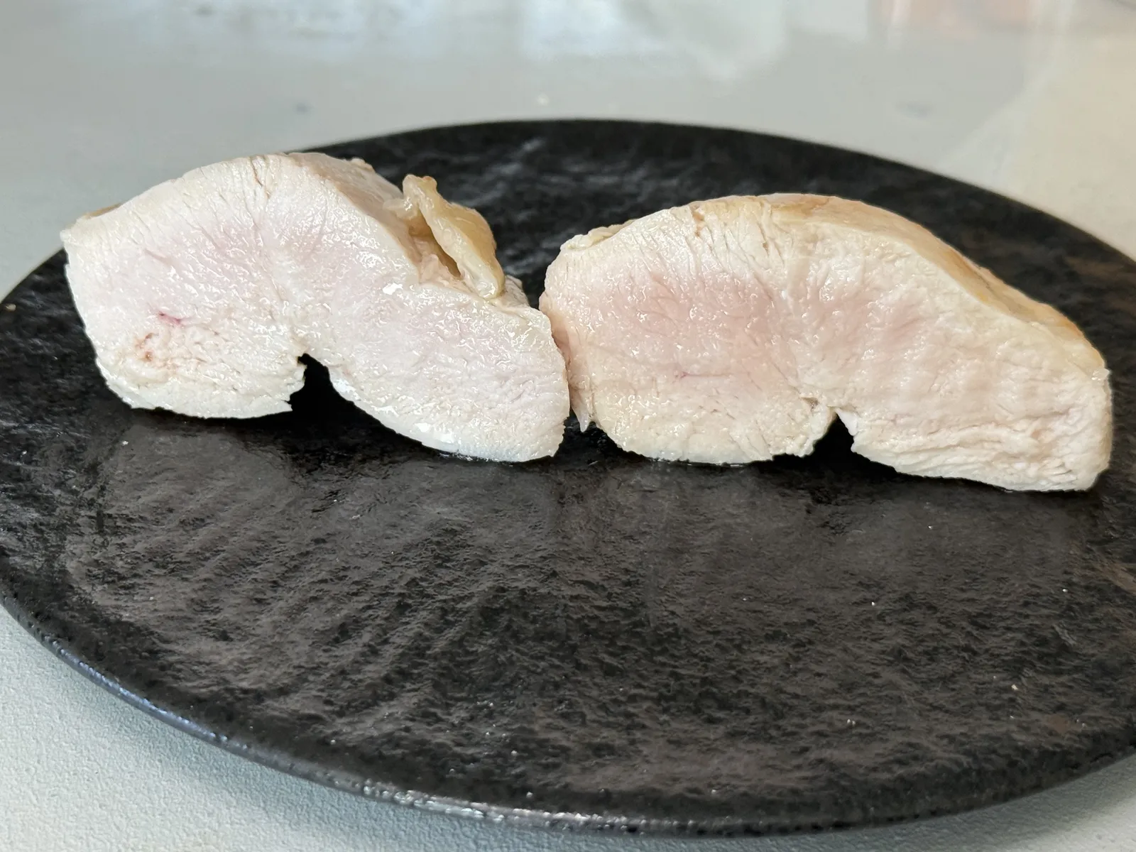 焼いた鶏むね肉の断面。左がブライン液に漬けたもの、右が何もしていないもの