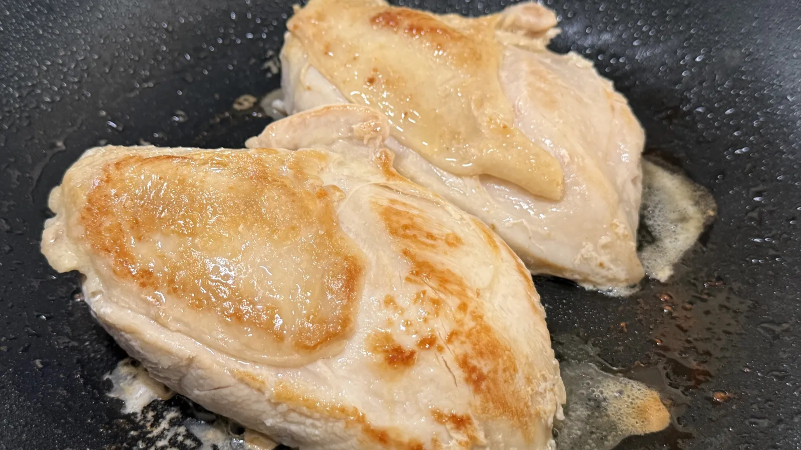 フライパンで焼いた鶏むね肉2枚。奥がブライン液に漬けたもの