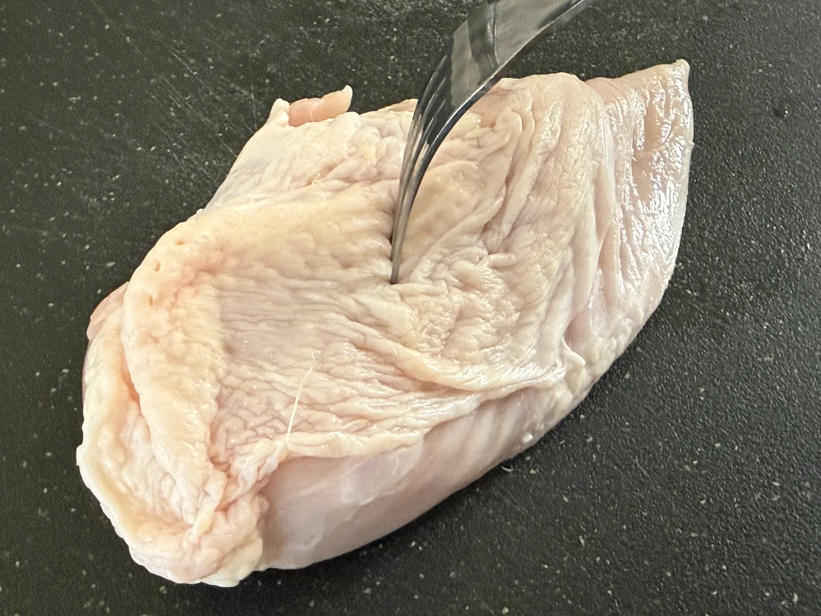 鶏むね肉にフォークで穴をあけるところ