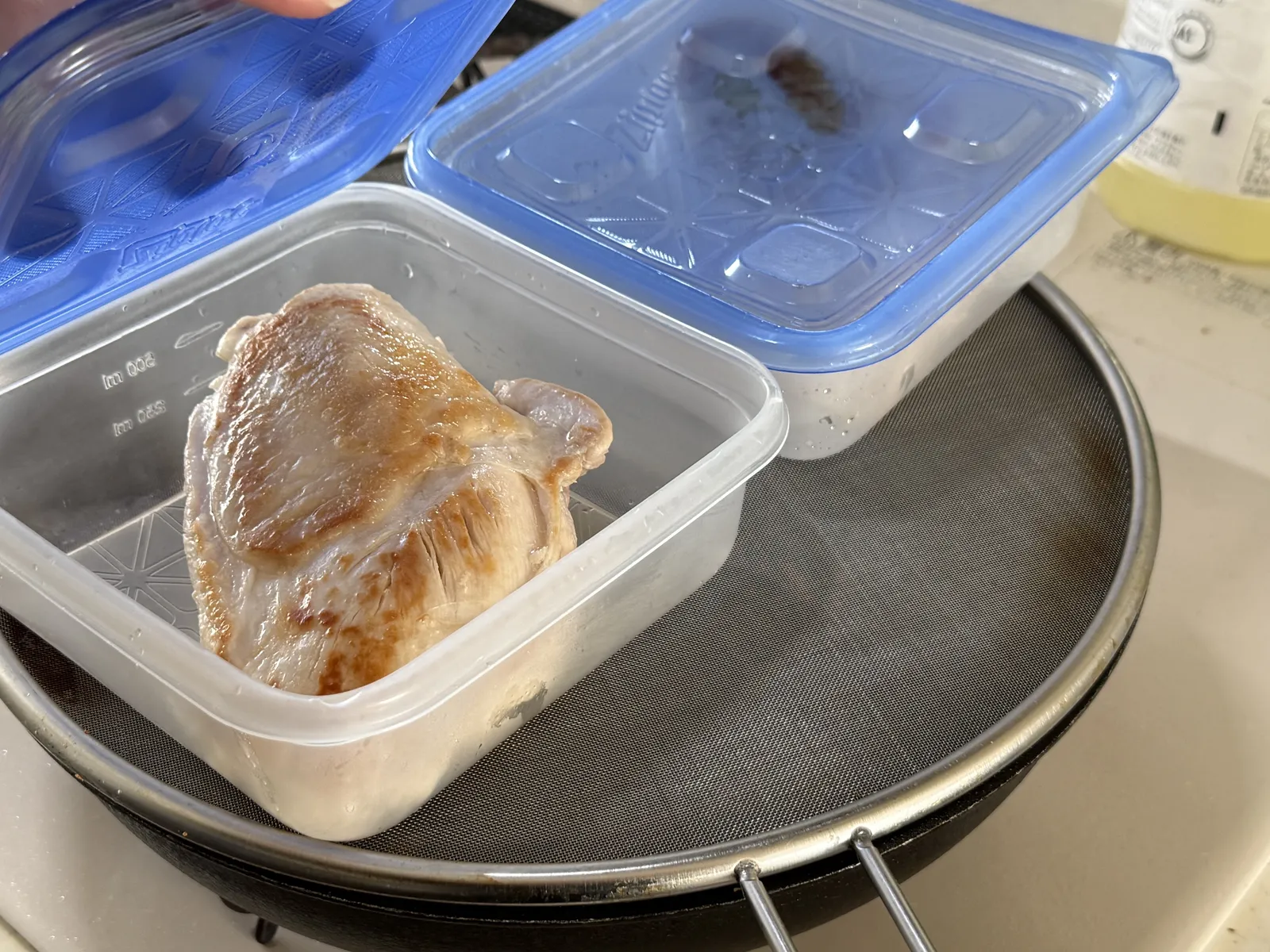 焼いた鶏むね肉を保存容器に入れ、余熱で火を通しているところ