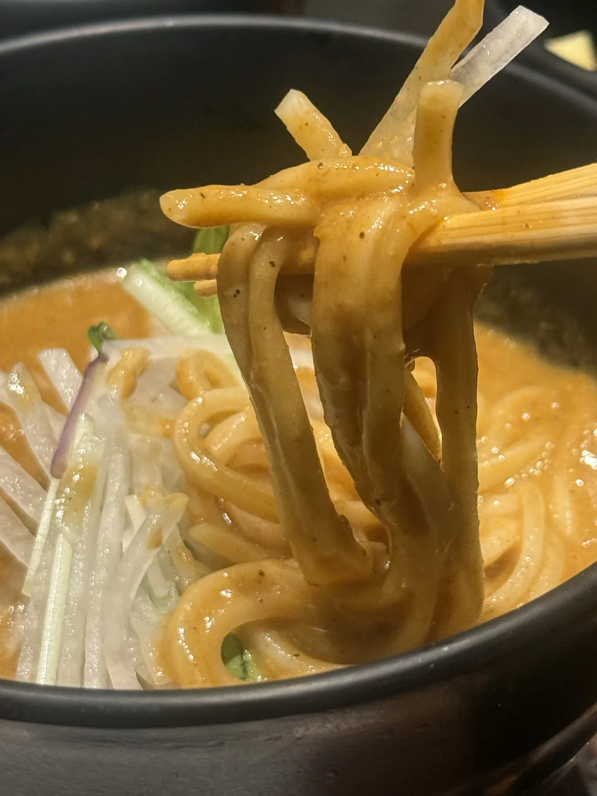 cuudのカレーうどんの中太麺を箸で持ち上げたところ