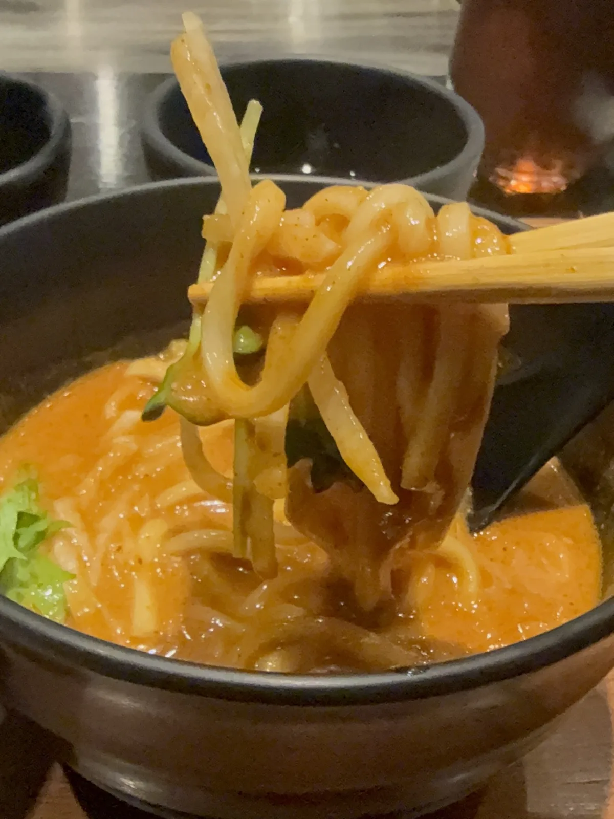 cuudのトマトカレーうどんの麺を箸で持ち上げたところ