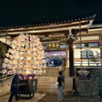 「法蓮寺」の額がかかるライトアップされた本堂と、その前に寄せられた万灯